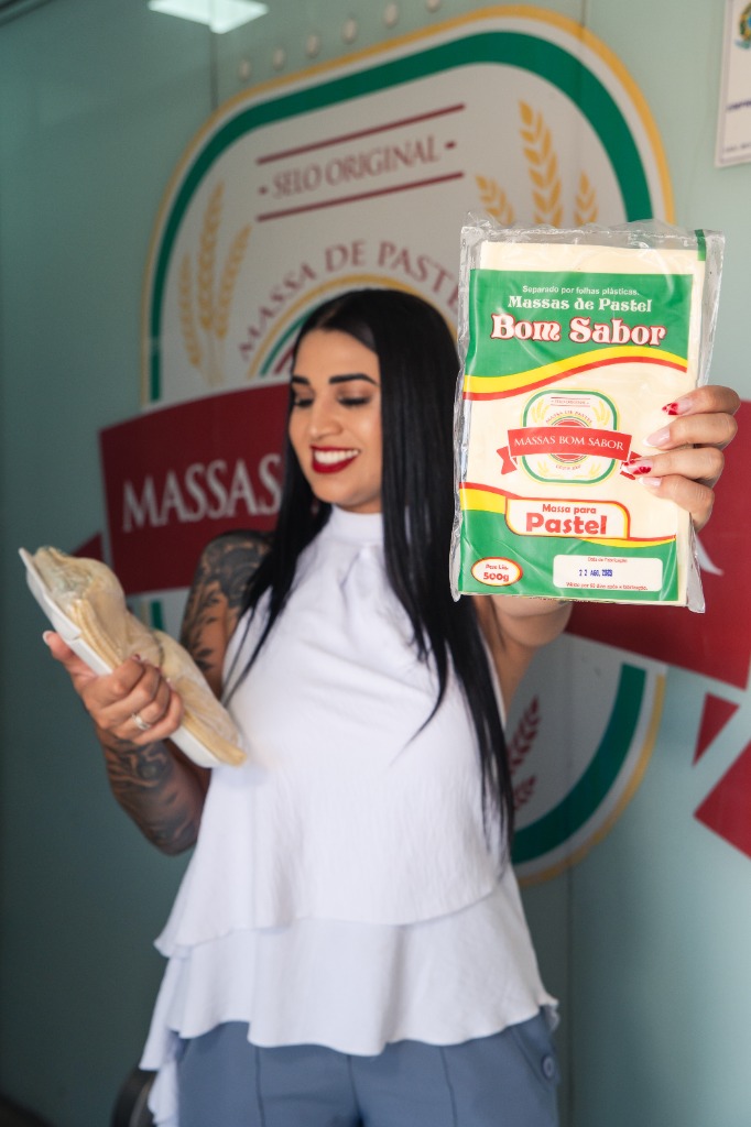 Equipe Massas Bom Sabor apresentando o pacote de 500g e a massa fresca artesanal